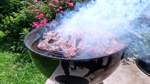 Lamb ribs are grilled over hot coals, the meat is turned with a spatula