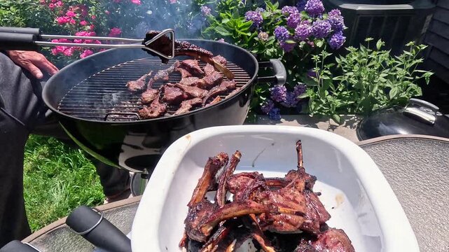 Lamb ribs are grilled over hot coals, the meat is turned with a spatula