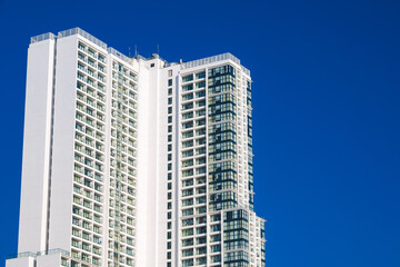 Fototapeta premium facade of the tall modern new skyscraper of hotel against the background of the blue sky