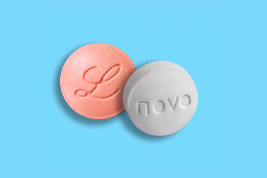 Weight-loss drug Wegovy tablet pills from Novo Nordisk and Foundayo pill from Eli Lilly on blue background. Copenhagen, Denmark - April 11, 2026