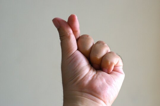 korean finger heart gesture against a neutral background