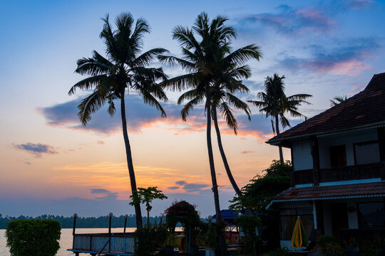 Luxury Tropical Resort at Sunset with Infinity Pool and Traditional Kerala Architecture on Vembanad Lake, India