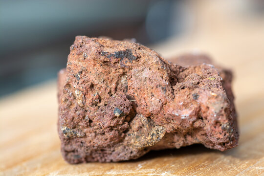 Macrophotographie d'une roche volcanique rouge poreuse (scorie).