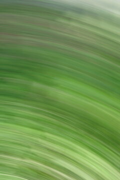 Abstract green motion blur background with curved lines and dynamic energy. This vibrant image captures the essence of nature in motion, evoking speed and growth. Ideal for eco-friendly branding.
