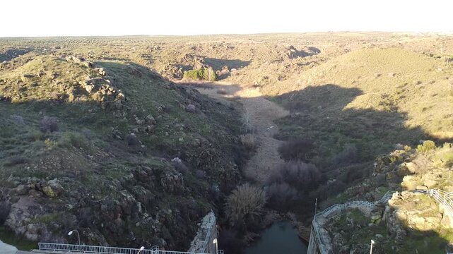 video a vista de p&aacute;jaro, sonde podemos ver el cauce por donde va el agua de un rio, al nacer de la desembocadura de la presa.