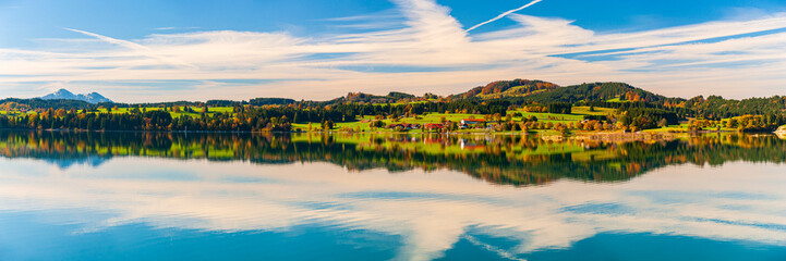 Fototapeta premium Panorama vom Forggensee im Allgäu bei Dietringen mit symmetrischer Wasserspiegelung