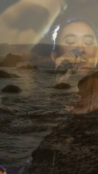 Vertical video: Singer starting music, moving mic, seascape through silhouette evoking coastal mood