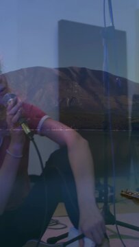 Vertical video: Guitarist playing urging singer picking mic singing in studio with mount or ship ble