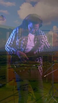 Vertical video: Camera rising, player playing bass during recording session, cloud overlay blending