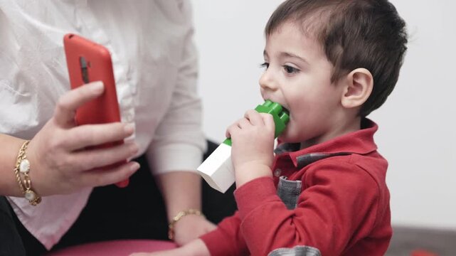 Toddler using a vibrating teether during speech therapy session