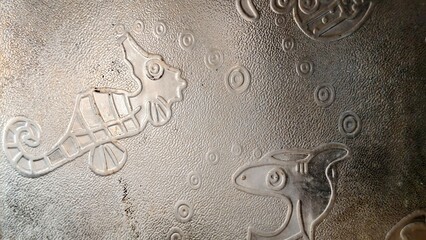 embossed seahorse and fish with bubbles on textured metallic background © Altaf