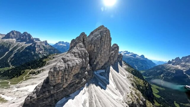 Epic aerial view of rugged mountain peaks and a serene lake under a vibrant blue sky during a sunny day