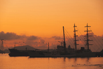 Obraz premium Silhouettes of Vietnamese warships military ships in port at sea in the morning at dawn in harbor in Nha Trang in Vietnam
