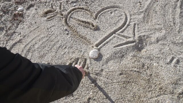 Heart sand drawing hand writes fourteen february date on beach for valentines day romantic gesture and holiday celebration