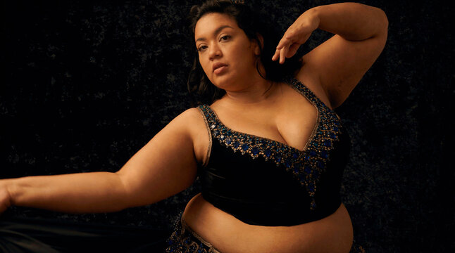 Confident Woman Performs an Expressive Dance in a Dazzling Beaded Crop Top on a Dark Stage