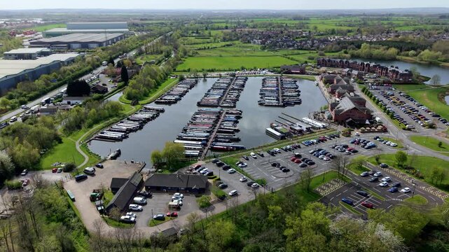 Aerial drone view of river barges and narrowboats moored in rows at Barton Marina, showcasing traditional canal culture and leisure travel near Burton on Trent, UK.