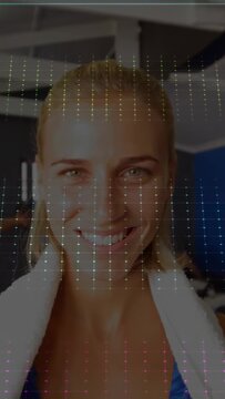 Vertical video: Recording woman wearing blue tank and white towel at gym, AR overlay showing HR