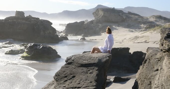teenage girl overlooking beautiful rocky coastline, Sopies Klip, Hermanus, South Africa