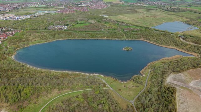 Aerial drone view of Albert Village Lake with blue waters and a small central island
