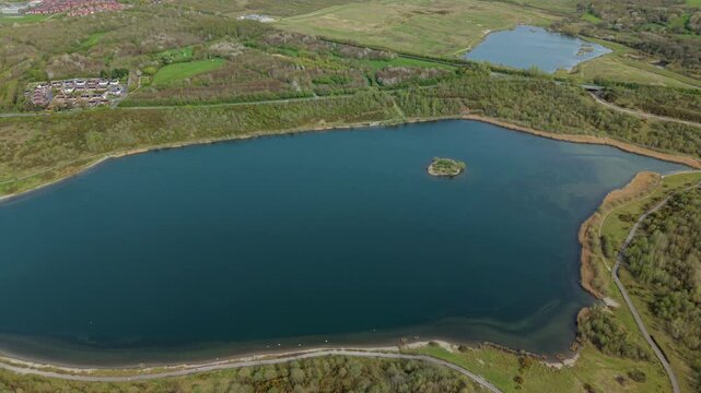 Aerial drone view of turquoise azure waters and a small central island at Albert Lake near Swadlincote UK