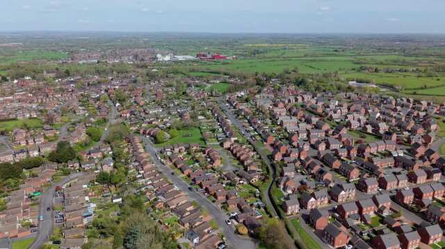Aerial drone view of new build residential houses and the historic town of Tutbury in Staffordshire UK