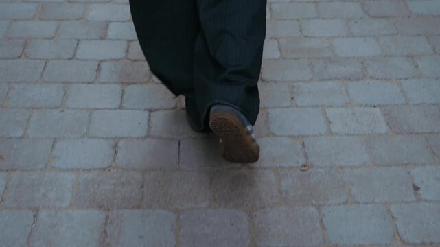 A close-up of a girl's legs as she walks down the street with a confident, smooth gait. The video highlights her natural gait and gentle sway, conveying a sense of freedom and the dynamic rhythm of ci