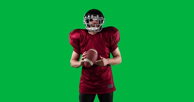 American football player with helmet holding ball against black background