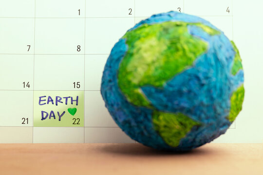 Globe with Earth Day marked on calendar, Global environmental awareness