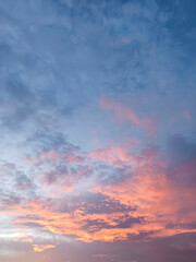 Fototapeta premium Dramatic Colorful sunset sky with soft blue clouds and glowing pink-orange hues, creating a serene and dreamy atmosphere. Ideal as a natural background or atmospheric landscape.