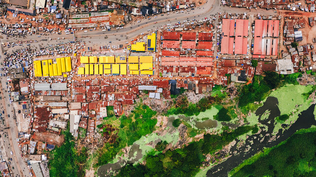 Aerial view of vibrant market stalls bursting with color against the backdrop of buildings and green vegetation, Abeokuta, Ogun State, Nigeria.