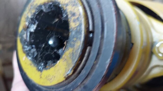 Close up of a tractor PTO shaft coupling with grease and spider web