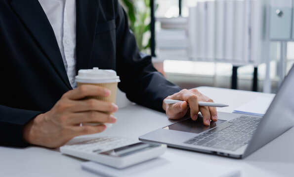 Businessman holding coffee reviewing financial data and accounting reports, consulting on investment strategy and professional financial advisory services.
