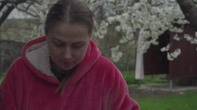 camera pans away from dirty mirror. Filming through mirror. tired, depressed housewife washes everyone else's dishes, cleaning kitchen, dacha, cold autumn. A young girl bright pink hoodie enjoying