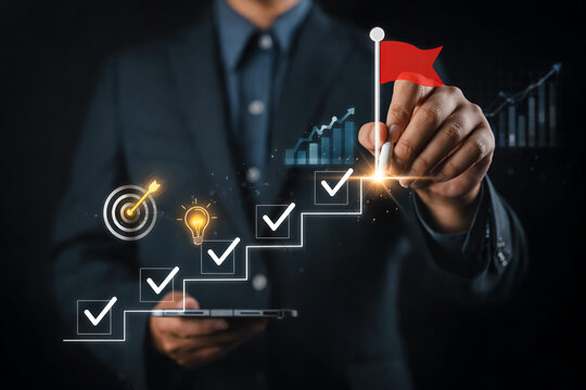 Businessman holds a mobile device while drawing a rising growth chart with checked boxes and a red success flag to visualize achieving financial targets and business goals.