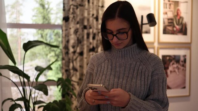 Young teenage girl using smartphone continuously distracted by screen digital dependency concept social media influence and modern youth lifestyle indoor close moment
