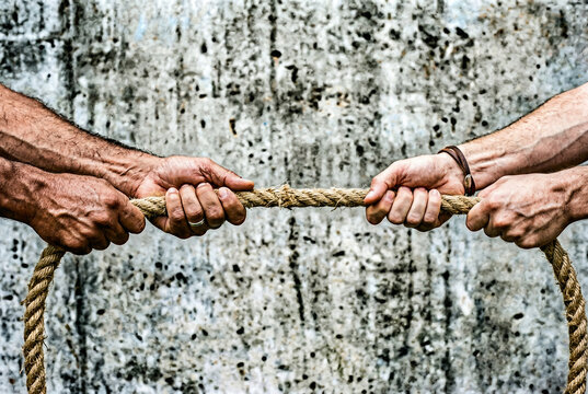 two hands pulling the rope in different directions, conflict