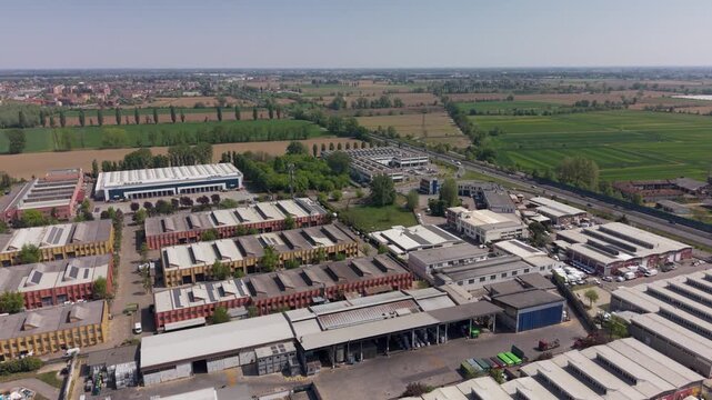 Aerial view of a food supply chain and logistics energy hub in Peschiera Borromeo, Milan, Italy. Industrial zone integrating dairy production, distribution networks and solar powered infrastructure.