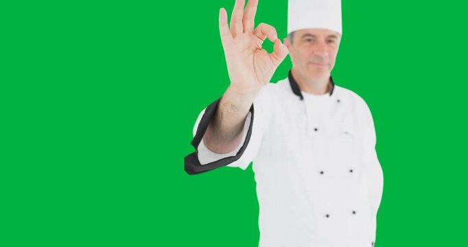Portrait of caucasian male chef gesturing okay sign against black background