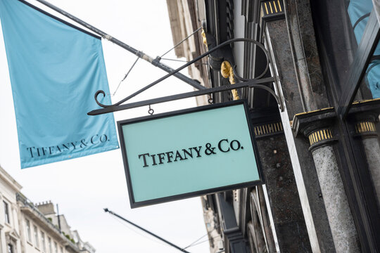 Brand logo and sign for Tiffany and Co store front a jewellery and luxury gifts shop in New Bond Street, a luxury shopping district in central London, UK.