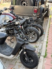 Motorcycle parts and scooters parked in urban street, showcasing mechanical details © dvoevnore