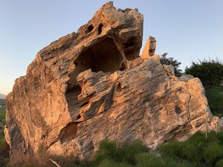 Large rock formation in natural landscape with sunlight illuminating surface texture © dvoevnore