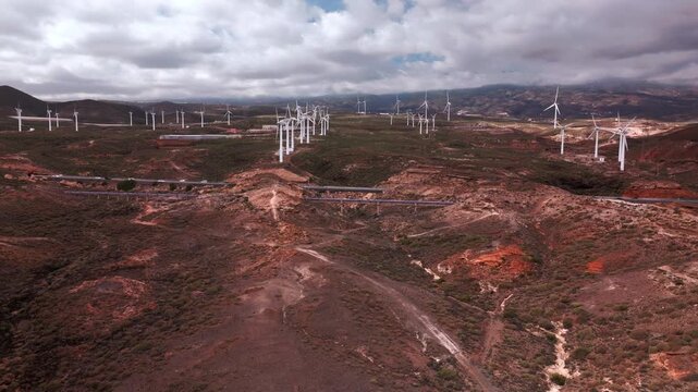 Drone aerial view of a large wind farm with multiple wind turbines producing renewable electricity, Tenerife