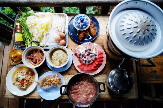 Top view of Moo Krata set, Thai food and Barbecue set on wooden table on terrace in Thailand
