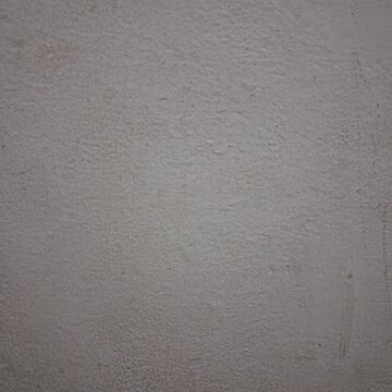 Rough white painted wall texture showing subtle variations and minor imperfections for background.