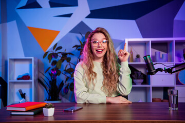 Young blogger recording content in a colorful home studio with modern equipment and microphone for...