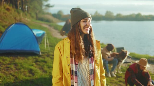 Woman smiling near tranquil lake, Candid portrait of woman with friends by peaceful lakeside backdrop