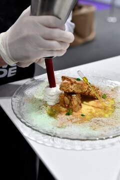 chef experto repostero elaborando postre con trota crujiente y aceite de oliva virgen extra y emplatando con crema pastelera