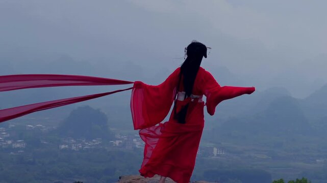 Guilin mountain top, woman in traditional red Hanfu, long silk flowing, cinematic mysterious misty atmosphere.showing a woman in a red Hanfu standing against misty karst mountains