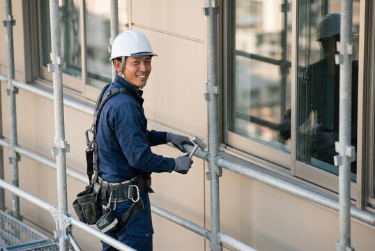 建設現場の足場で笑顔を見せる作業員の男性