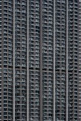 Fototapeta premium Close-up view of a massive modern residential apartment facade showcasing dense balconies, windows, and repetitive architectural patterns.